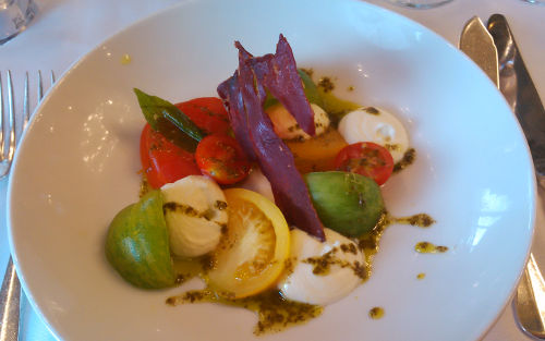 Collection of tomatoes, creamy mozzarella, crispy Serrano